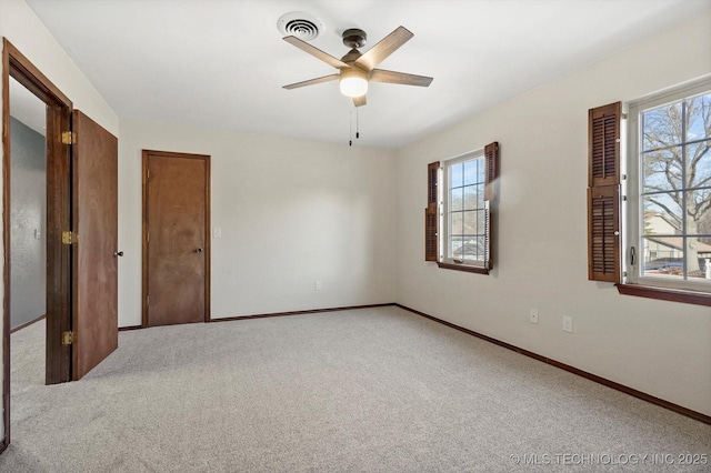 unfurnished bedroom featuring light carpet, ceiling fan, visible vents, and baseboards