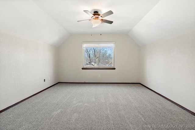 additional living space with carpet, baseboards, and vaulted ceiling