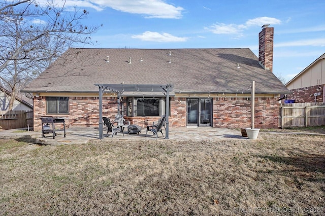 back of house with brick siding, a patio, fence, a pergola, and a fire pit