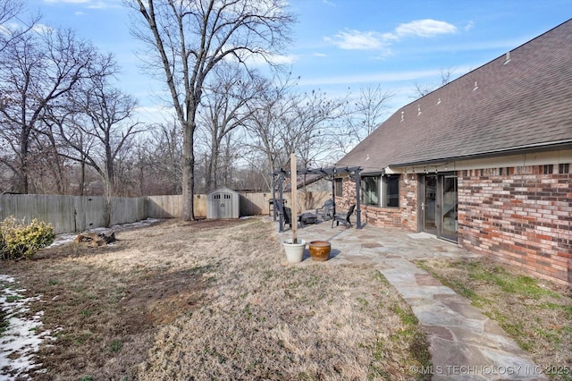 view of yard featuring an outbuilding, a patio, a shed, and a fenced backyard