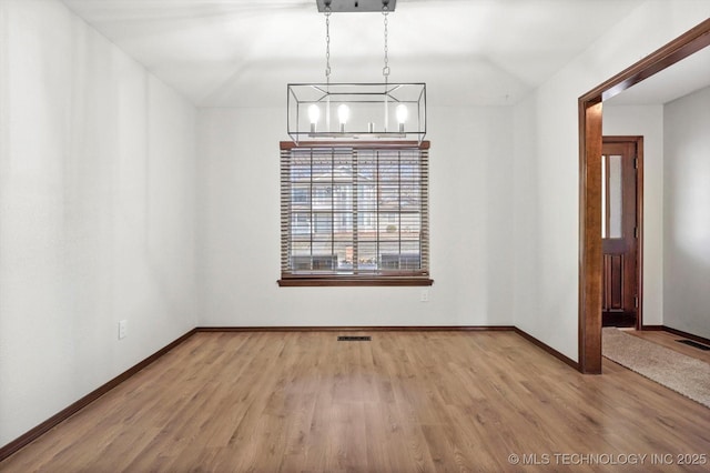 unfurnished dining area featuring light wood-type flooring, visible vents, and baseboards