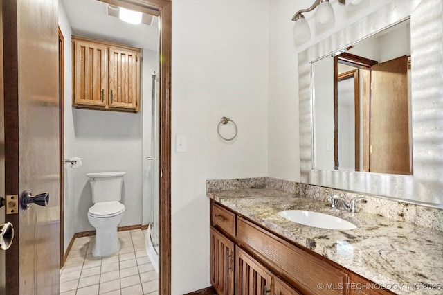 bathroom with toilet, a shower stall, vanity, baseboards, and tile patterned floors