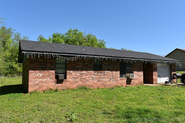 view of front of house featuring an attached garage, a front lawn, and brick siding