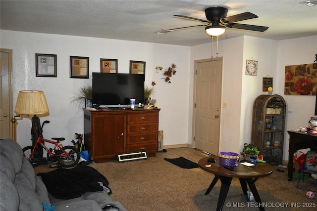 living room with carpet floors, visible vents, ceiling fan, and a textured ceiling