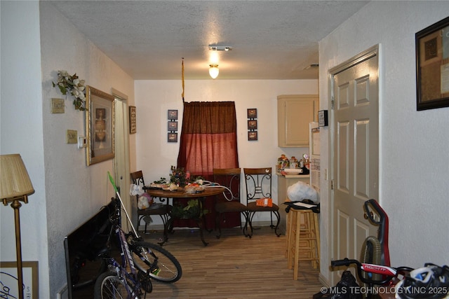 dining area with a textured ceiling and wood finished floors