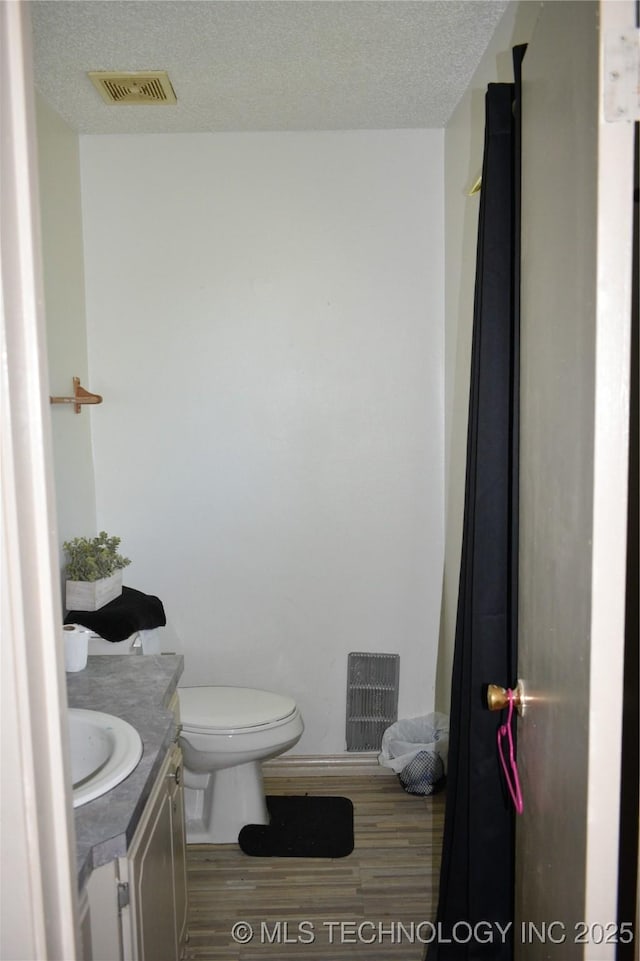 bathroom featuring visible vents, vanity, a textured ceiling, and wood finished floors