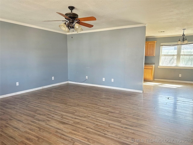 spare room with baseboards, ornamental molding, and dark wood finished floors