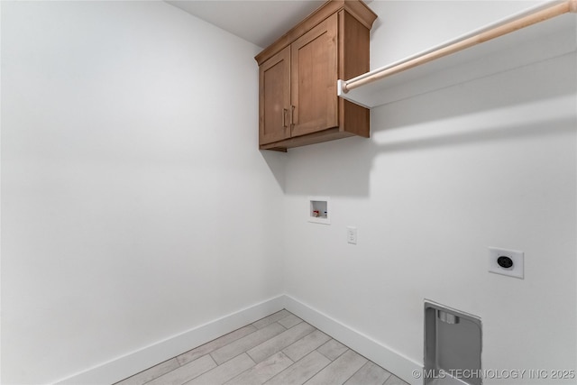 clothes washing area with cabinet space, baseboards, light wood-style flooring, hookup for a washing machine, and electric dryer hookup