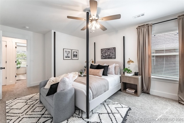 bedroom with a ceiling fan, light colored carpet, visible vents, and baseboards