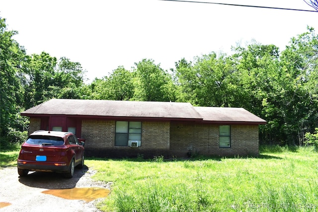 ranch-style home with a front yard and brick siding