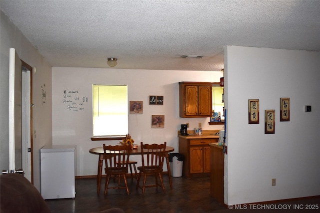 dining space featuring visible vents and a textured ceiling