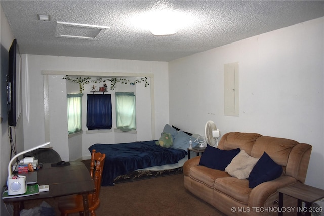 bedroom with a textured ceiling, carpet floors, attic access, and electric panel