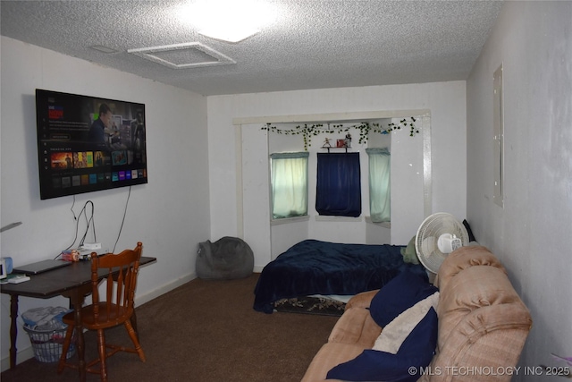 bedroom with a textured ceiling, carpet, and attic access