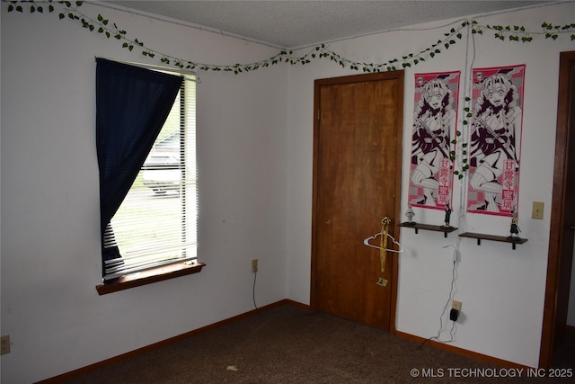 unfurnished room with a textured ceiling, carpet floors, and baseboards