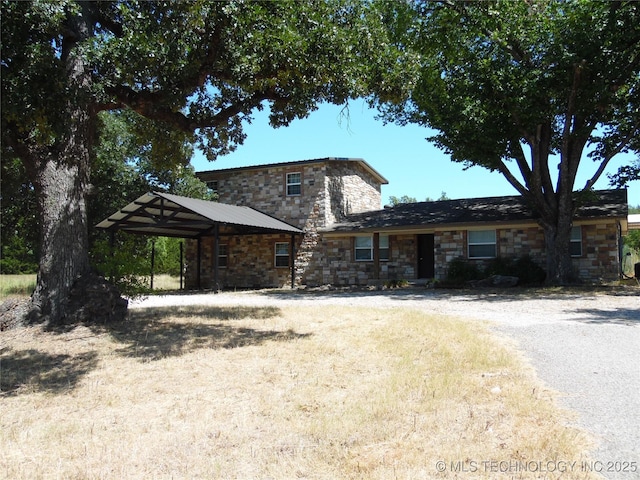 view of front of home featuring driveway, a carport, and stone siding