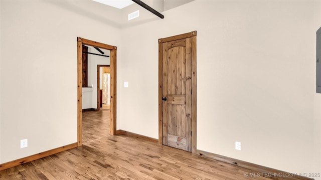 spare room featuring visible vents, light wood-style flooring, and baseboards