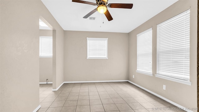 unfurnished room featuring visible vents, plenty of natural light, baseboards, and light tile patterned floors