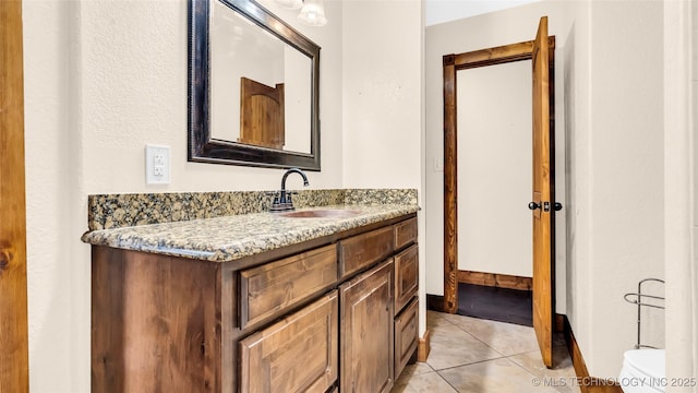 bathroom with vanity, baseboards, and tile patterned floors