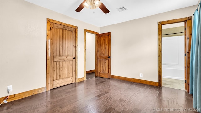 unfurnished bedroom with visible vents, dark wood-type flooring, ceiling fan, ensuite bath, and baseboards