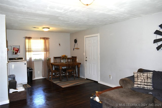 living room featuring dark wood-style floors, washer / clothes dryer, visible vents, and baseboards