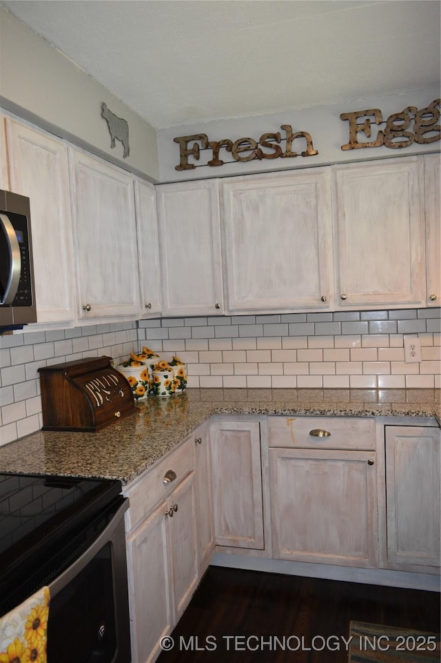 kitchen with appliances with stainless steel finishes, decorative backsplash, and light stone countertops