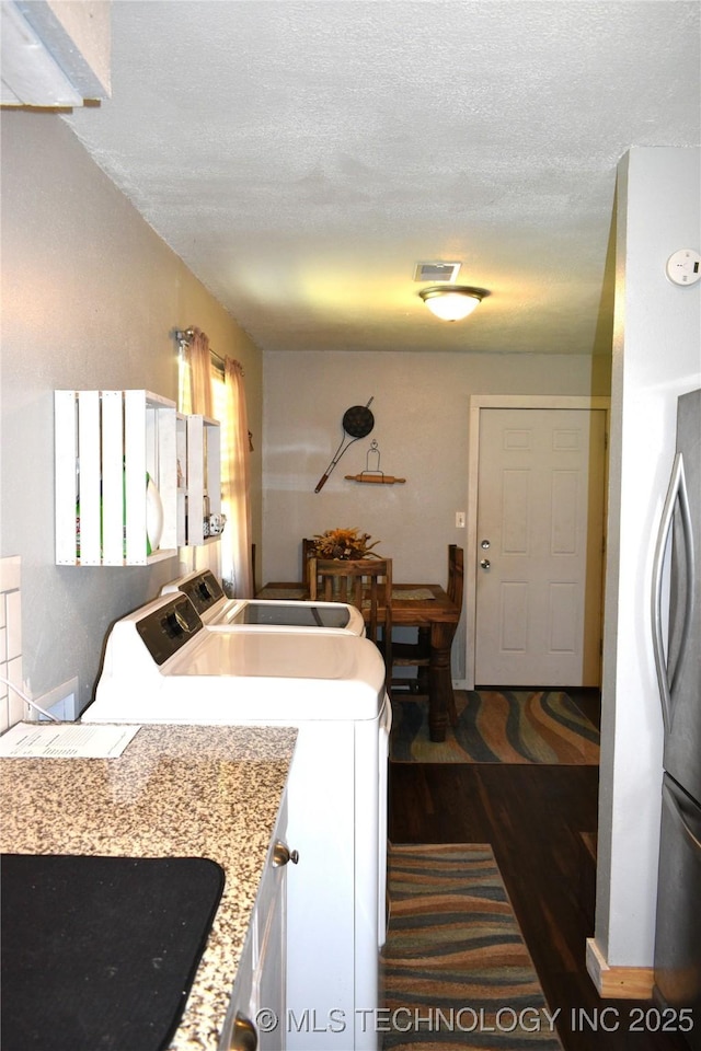 kitchen with visible vents, dark wood-style floors, washer / clothes dryer, light countertops, and a textured ceiling