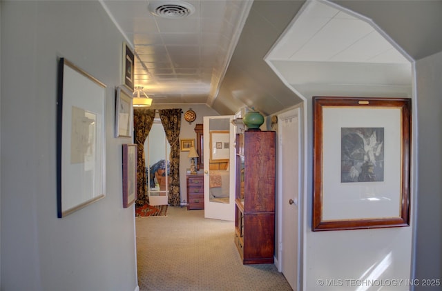 corridor with vaulted ceiling, carpet, and visible vents