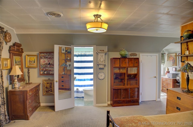 bedroom featuring baseboards, crown molding, visible vents, and light colored carpet