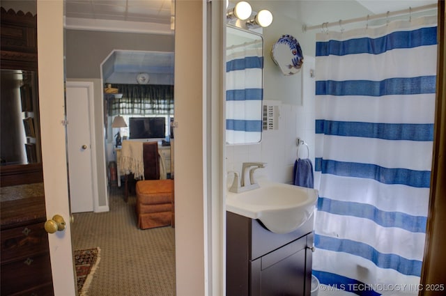 ensuite bathroom with tile walls, vanity, curtained shower, and ensuite bathroom