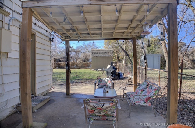 view of patio featuring a storage shed, fence, and an outdoor structure