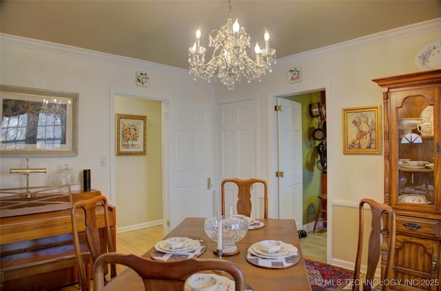 dining area featuring crown molding, light wood-style flooring, baseboards, and an inviting chandelier