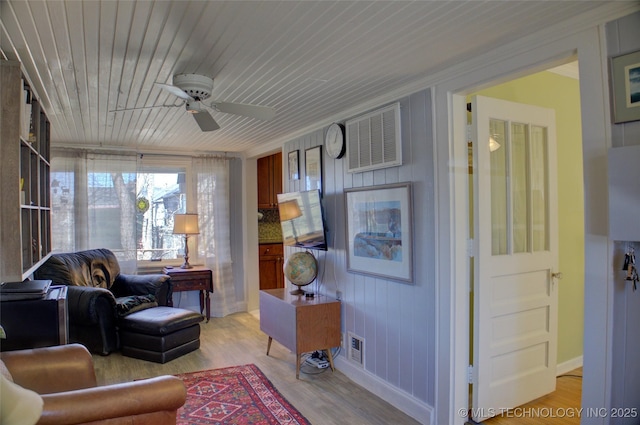 sitting room featuring wood ceiling, light wood-type flooring, visible vents, and a ceiling fan