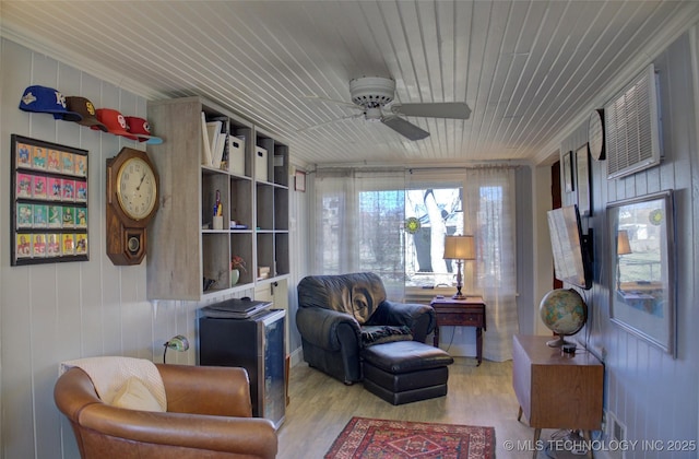 living area with ceiling fan, wooden ceiling, and wood finished floors