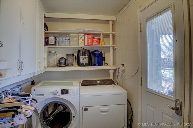 washroom with washing machine and clothes dryer and cabinet space