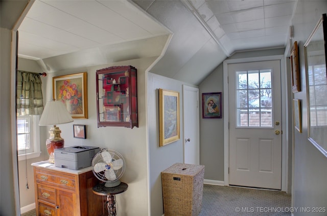 doorway featuring carpet floors, vaulted ceiling, and baseboards