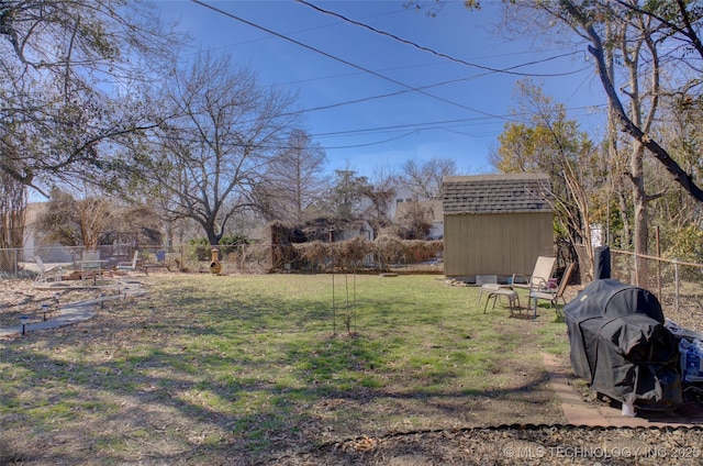 view of yard featuring an outbuilding, a storage unit, and fence