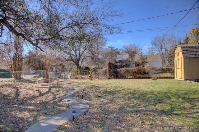 view of yard featuring a shed, a fenced backyard, and an outdoor structure