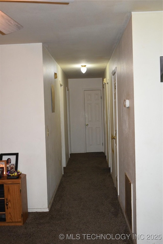 corridor featuring visible vents and dark carpet