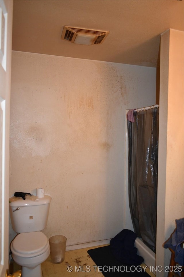 bathroom with visible vents, a shower stall, and toilet