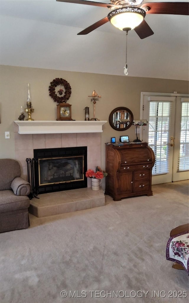 carpeted living area featuring ceiling fan and a tile fireplace