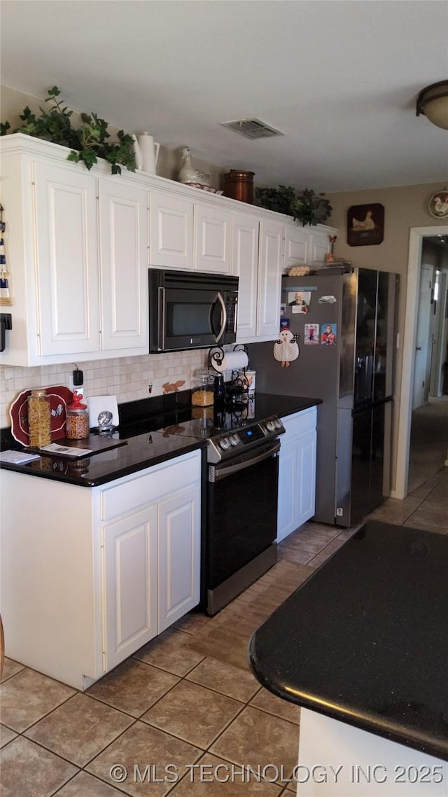 kitchen featuring black microwave, visible vents, electric range oven, dark countertops, and white cabinetry