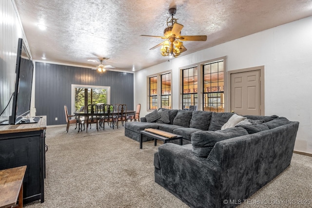 carpeted living area featuring a textured ceiling, baseboards, and a ceiling fan