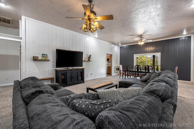 living area featuring light carpet, baseboards, visible vents, ceiling fan, and a textured ceiling