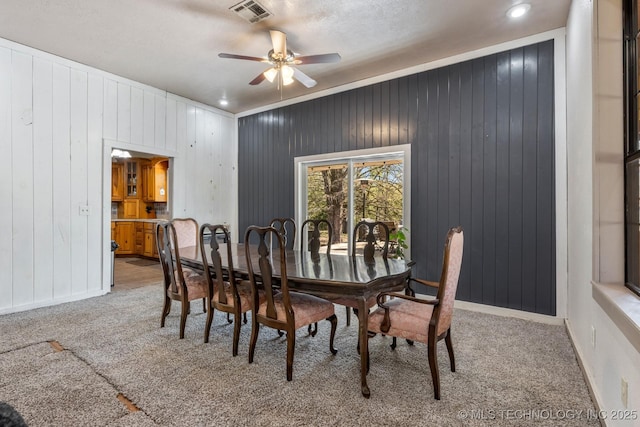 carpeted dining area featuring visible vents, ceiling fan, and baseboards