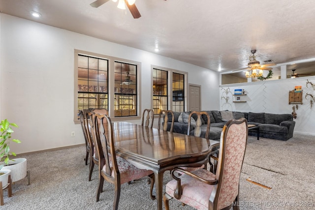 carpeted dining space with a textured ceiling, a ceiling fan, and baseboards