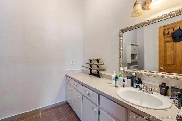 bathroom featuring tile patterned flooring, baseboards, vanity, and toilet