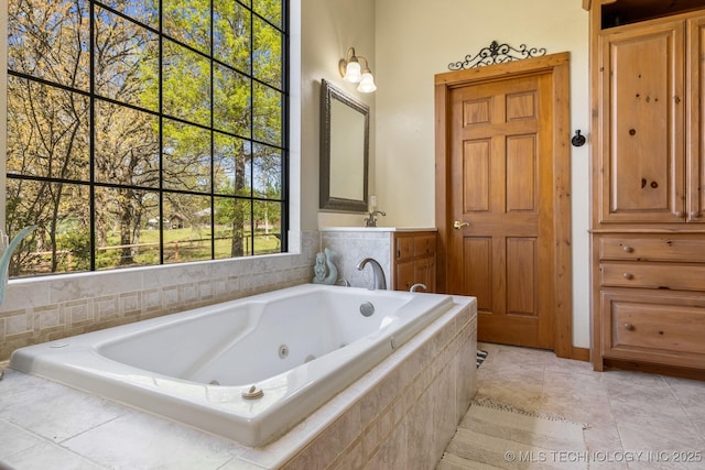 bathroom featuring a whirlpool tub, tile patterned floors, and vanity