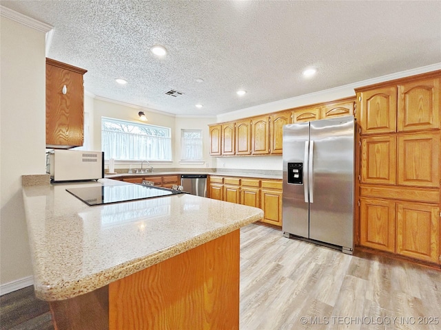 kitchen with a peninsula, brown cabinetry, stainless steel appliances, and crown molding