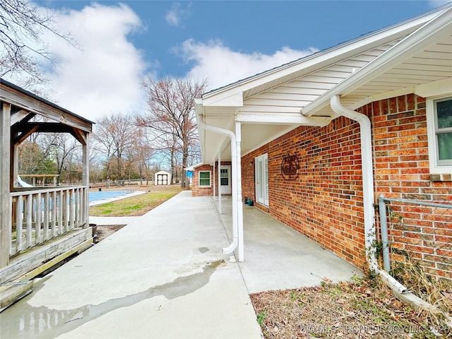 view of patio with a storage shed and an outbuilding