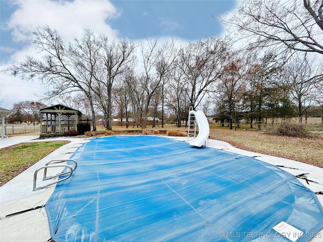 view of swimming pool with a fenced in pool, a water slide, and a gazebo